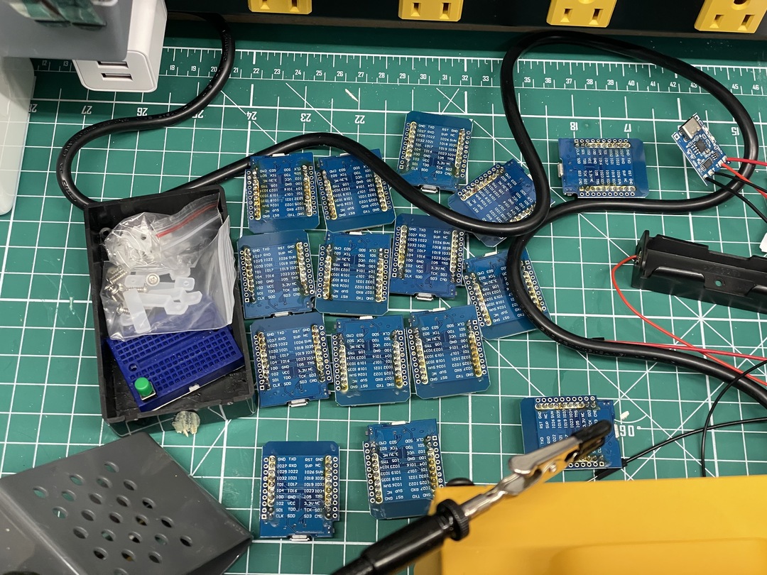 A pile of blue breakout boards with scattered components on a workbench.